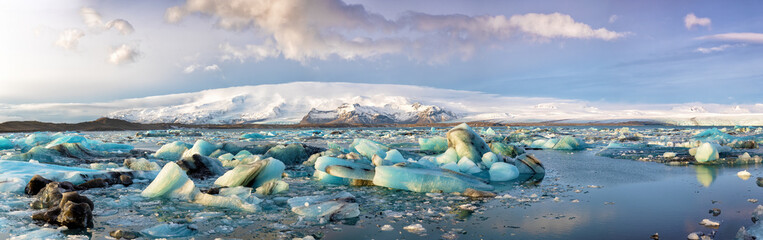 Wall Mural - panorama of blue glacial ice floating in the jokulsarlon lagoon, iceland in winter.