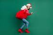© deagreez - Full length profile photo of cute young lady go with bag wear new year pullover cap jeans shoes isolated on green color background
