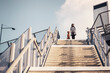 © Maskot - Low angle view of woman and dog standing on staircase