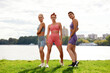 © Georgii - Group of three woman warms up in park before jogging. Healthy lifestyle concept. Sporty females friends having fun and doing different stretching exercises in summer park.