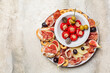 Appetizers. Bruschetta, cold cuts of prosciutto from Parma, cheese, tuna fish stuffed mini bell peppers, taralli, olives, grapes and figs. Traditional italian aperitivo. Copy space.