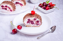 Cream cake with cherries on a white plate