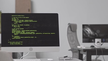 Stab shot of lines of computer codes appearing on black screen of computer monitor in programmers office