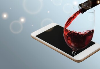 Wall Mural - Modern artwork. Glass filling with wine from a bottle in phone screen