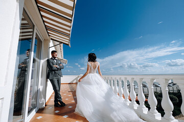 bride and groom newlyweds at the sea. lovely young couple, woman in wedding dress and man in suit by the sea or ocean are spending their honeymoon