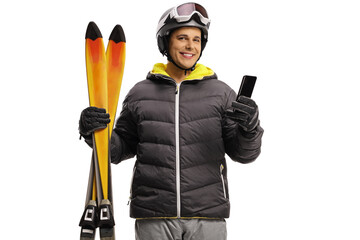 Canvas Print - Young man with skiis smiling and holding a mobile phone