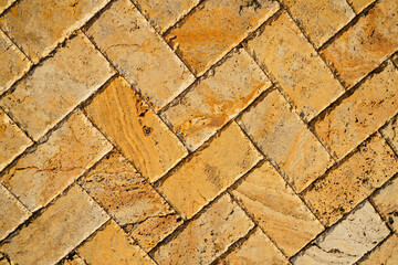 Wall Mural - Yellow brown stone pavers background. Neutral texture of a flat brick wall close-up.        