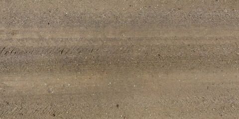 Wall Mural - top panorama view from above on surface of gravel road with car tire tracks