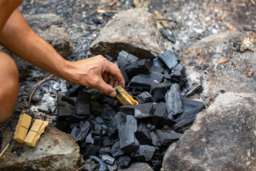 Wall Mural - Man making a fire for a barbecue on a camp