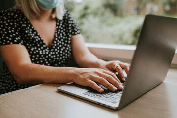 Sticker - Woman  wearing mask using laptop on a train in the new normal