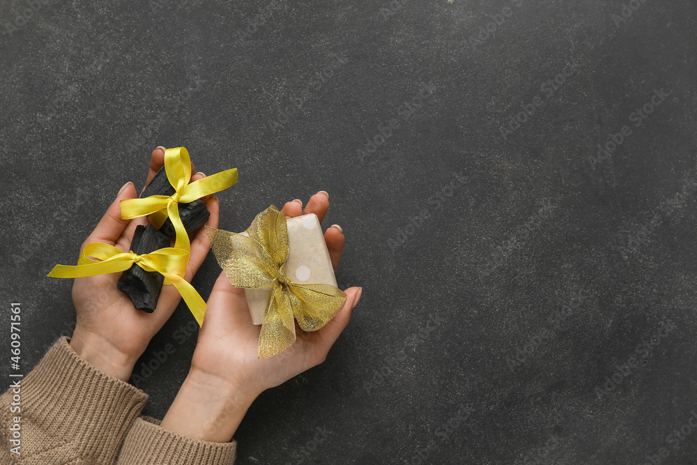 Woman with coal and gift on dark background