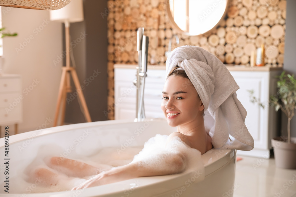 Young woman taking bath with foam at home
