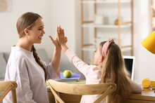 Little Girl And Her Mother Giving Each Other High-five At Home