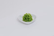 white plate green wasabi sauce on a white background