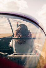 Blond Woman Wearing Headphones In Propeller Airplane