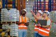 A small group of warehouse workers has a briefing in a large distribution center. concept of teamwork and occupation.