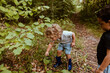 © Westend61 - Boy examining plant through magnifying glass with male friend in forest
