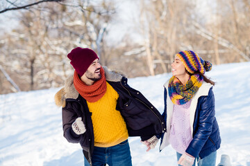 Poster - Photo of attractive young couple happy positive smile go walk run park hold hands together weekend winter snow