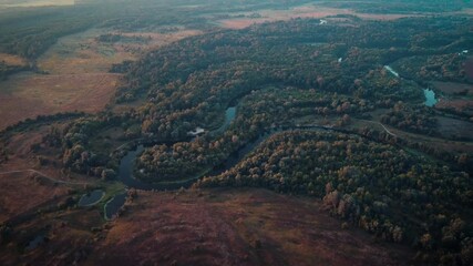 Poster - Waving watercourse of a river in the countryside lit by first sun rays in the morning. Cinematic video of beautiful nature