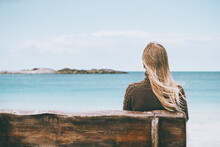 Woman Sitting On Wooden Bench Looking At Sea View Alone Harmony With Nature Concept Outdoor Vacations In Norway