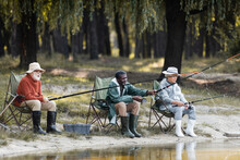 Multiethnic Elderly Men With Fishing Rods Spending Time Near Lake