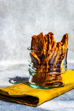 Sliced, Dried And Dehydrated Persimmon Fruit In A Glass On A Folded Napkin