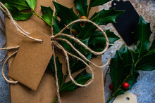 Wrapped Gift Box Decorated With Fresh Holly For Christmas