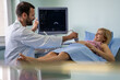 © NDABCREATIVITY - Pregnant young woman at gynecologist having her baby examined with ultrasound device.