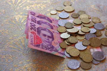 Ukrainian money. Two hundred hryvnia and coins on a blurred background. Selective focus with copy space.