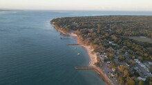 Waterfront Rural Town Of Amity Point In North Stradbroke Island By Coral Sea - Groyne And Fishing Pier. - Aerial Pullback