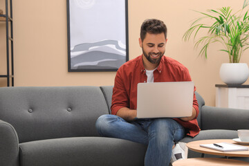 Wall Mural - Man using laptop for online shopping at home