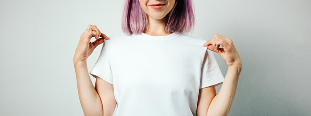pretty plus size model with white blank t-shirt and pink hear, empty grunge wall background. holding