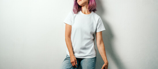 Pretty plus size model with white blank t-shirt and pink hear, empty grunge wall background. Standing relaxed