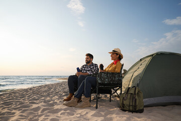 Sticker - Couple with thermoses near camping tent on beach