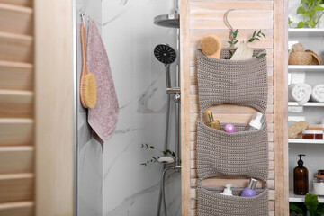 Wall Mural - Knitted organizer hanging on wooden door in bathroom