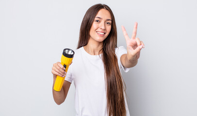 Poster - young pretty woman smiling and looking happy, gesturing victory or peace. lantern concept