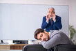 © Elnur - Old businessman and young male employee in front of whiteboard