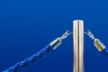 Barrier Fence, Velvet And Metal Racks. Close-up Of A Portable Barrier With A Blue Rope Against A Blue Background.