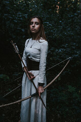 girl in a historical dress in a coniferous forest