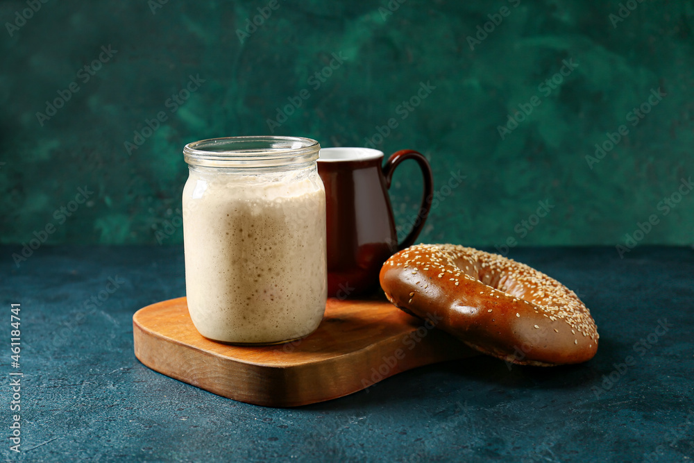 Jar with fresh sourdough and bagel on table