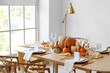 © Pixel-Shot - Dining table with pumpkins near window in room