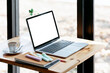 © NAMPIX - Mockup blank white screen laptop computer on wooden table in cafe room,