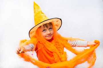 Wall Mural - boy in halloween costume, orange witch hat, cobwebs and spiders.