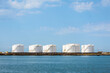 © olrat - White storage tanks in a marine oil terminal