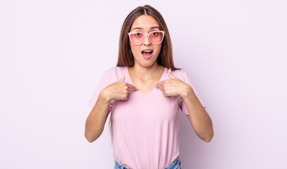 Poster - young pretty woman feeling happy and pointing to self with an excited. pink sunglasses concept