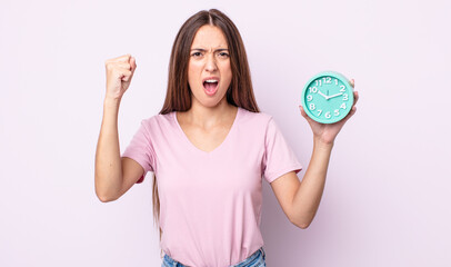 Poster - young pretty woman shouting aggressively with an angry expression. alarm clock concept