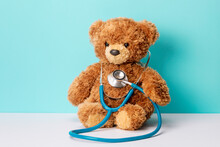 Pediatrics. Teddy Bear With A Stethoscope. Teddy Bear On A Green Background