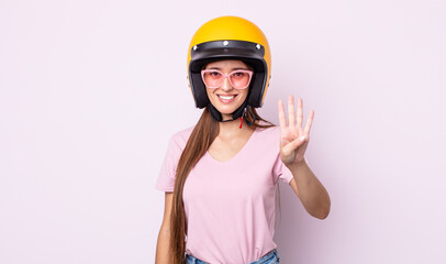 Poster - young pretty woman smiling and looking friendly, showing number four. motorbike rider and helmet