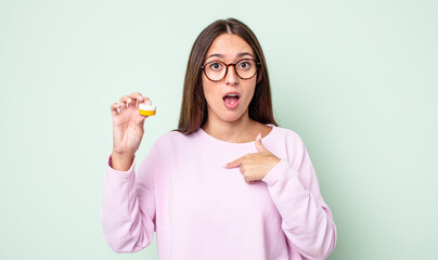 Poster - young pretty woman looking shocked and surprised with mouth wide open, pointing to self. contact lenses concept