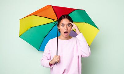 Poster - young pretty woman looking surprised, realizing a new thought, idea or concept. umbrella concept